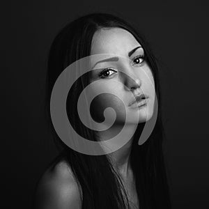 Dramatic portrait of a girl theme: portrait of a beautiful girl on a dark background in studio