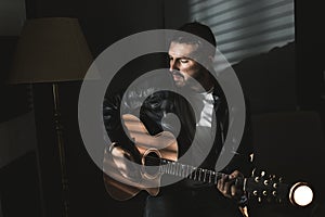 Dramatic portrait of a man playing a guitar. Guitarist