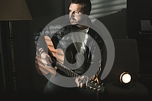 Dramatic portrait of a man playing a guitar. Guitarist