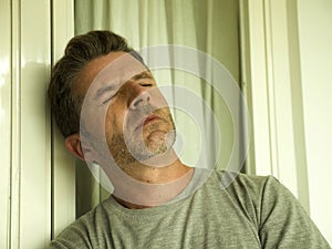 Dramatic portrait of middle aged sad and depressed man in pain feeling stressed and frustrated suffering depression problem and