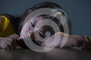 Dramatic portrait scared and stressed Asian Korean teen girl or young woman with mobile phone suffering cyber bullying stalked and photo