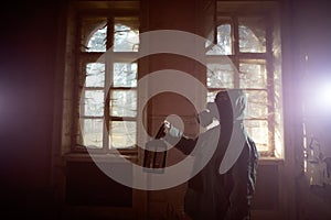 Dramatic portrait of a woman wearing a gas mask in a ruined building