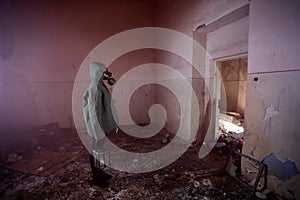 Dramatic portrait of a woman wearing a gas mask in a ruined building