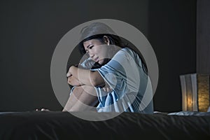 Dramatic portrait of young beautiful and sad Asian Korean woman crying desperate on bed awake at night suffering depression crisis