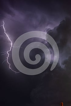 Dramatic purple lightning bolt in the dark night sky