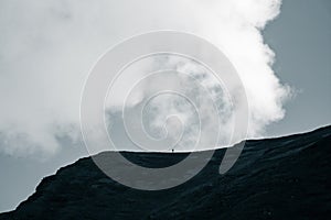 Dramatic rain clouds over the mountain top silhouette. Mountain landscape in summer.