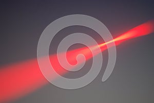 Dramatic Red Light Beam in Gray Sky
