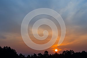 Dramatic red sunset over a forest silhouette