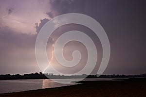 Dramatic river landscape image of lightning strike near river Waal  in the Netherlands