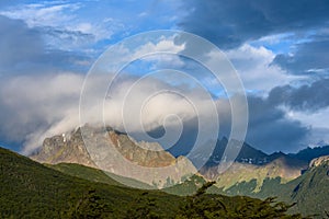 Dramatic scenic view, cloudy sky and early evening sun highlighting mountain peaks, Cerro Alarken Nature Reserve, Ushuaia, Argenti