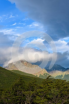 Dramatic scenic view, cloudy sky and early evening sun highlighting mountain peaks, Cerro Alarken Nature Reserve, Ushuaia, Argenti