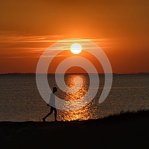 Dramatic Sea sunset with the silhouette of a walking person