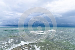 Dramatic seascape in dark colors. Dark sky with clouds over the stormy sea.