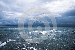 Dramatic seascape in dark colors. Dark sky with clouds over the stormy sea.