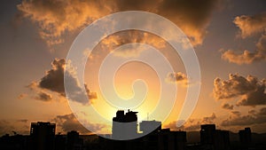 Dramatic silhouette city skyline timelapse at sunset with clouds moving over city