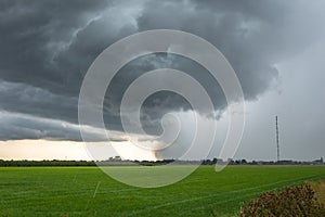 Fast moving thunderstorm over the green, wide open landscape of Holland photo