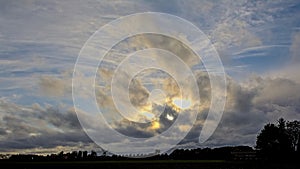 Dramatic sky with evening sun shing through dark clouds photo