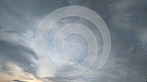 A dramatic sky with a mix of dark gray and light orange clouds. The clouds are thick and appear to be moving quickly.