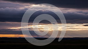 Dramatic sky over a landscape at sunset, featuring layers of