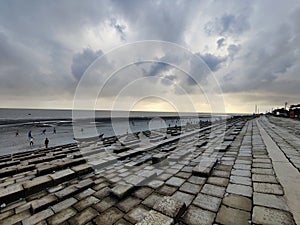 Dramatic sky over the pier at low tide in the evening