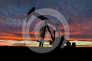 Dramatic Sky Over Pumpjack Silhouette in Rural Alberta, Canada