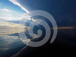 Dramatic Sky Over Water with Sun Rays and Storm Clouds