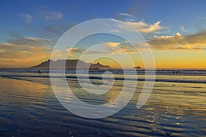 Dramatic sky at sunset beach in Bloubergstrand cape town with table mountain at back drop