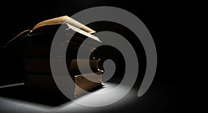 Stack of Old Books Illuminated by Dramatic Spotlight ancient vintage
