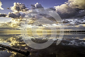 Dramatic Storm Clouds over a calm lake at sunrise