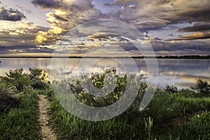 Dramatic Storm Clouds over a calm lake at sunrise