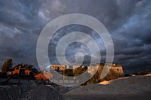 Dramatic storm clouds over the rooftops at summer sunset