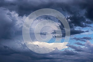 Dramatic storm grey clouds against blue sky background texture