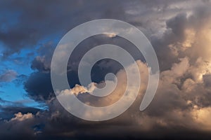 Dramatic storm grey cumulus clouds against blue sky background texture