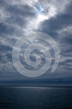 Dramatic stormy dark cloudy sky over sea, natural photo background