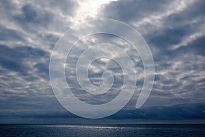 Dramatic stormy dark cloudy sky over sea, natural photo background