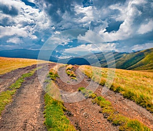 Dramatic summer scene of Svydovets mountain range with old country road.