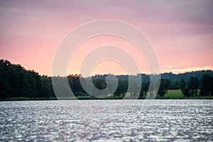 Dramatic summer sunset at the river with blue sky, red and orange clouds