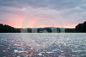 Dramatic summer sunset at the river with blue sky, red and orange clouds