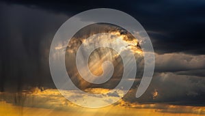 Dramatic sunbeams breaking through stormy clouds at sunset