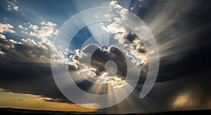 Dramatic sunbeams breaking through stormy clouds at sunset