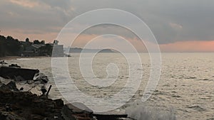 Dramatic sunrise ocean sea beach as a wave crashes over it and a seagull crosses the scene