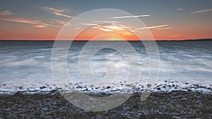 dramatic sunrise over the baltic sea with rocky beach and trees