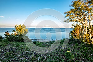 dramatic sunrise over the baltic sea with rocky beach and trees