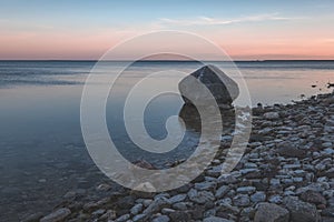 dramatic sunrise over the baltic sea with rocky beach and trees