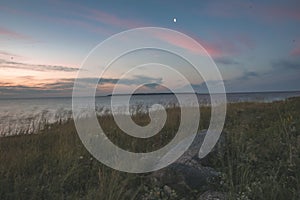 dramatic sunrise over the baltic sea with rocky beach and trees