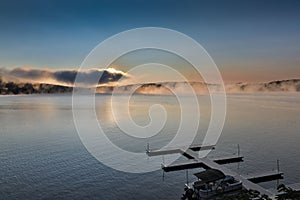 Dramatic sunrise over Deep Creek Lake with an empty dock. Maryland, USA.