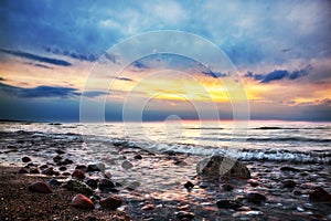 Dramatic sunrise on a rocky beach. Baltic sea