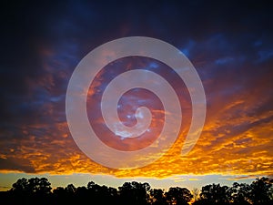 A Dramatic Sunrise sky with clouds above forest in rural town of Australia.