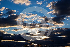 Scenery. Dramatic sunset on the background of the forest. The last rays of the sun break through heavy thunderclouds