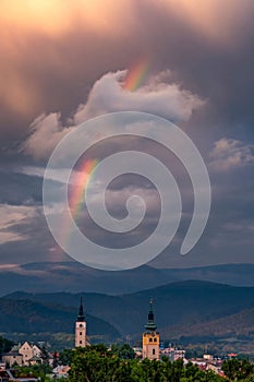 Dramatic sunset with beautiful rainbow over Banska Bystrica city in central Slovakia, vertical shot